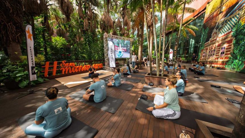 Grupo praticando yoga ao ar livre em evento de shopping