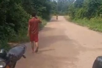 Homem caminha em estrada de terra, possivelmente após atropelamento em Maués.