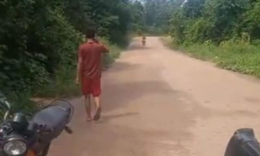 Homem caminha em estrada de terra, possivelmente após atropelamento em Maués.