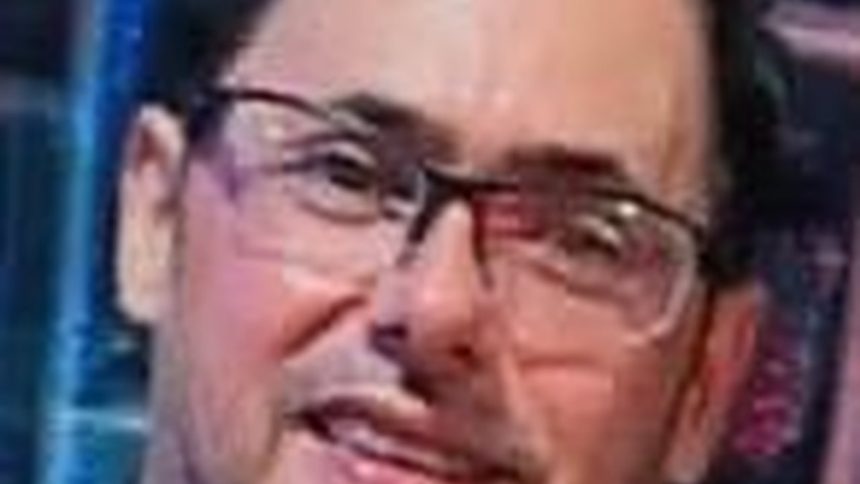 Homem de óculos escuros, suspeito de tráfico de drogas, procurado pela polícia.