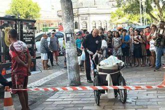 Homem é liberado após prestar depoimento na DEHS em cena com viatura e público.