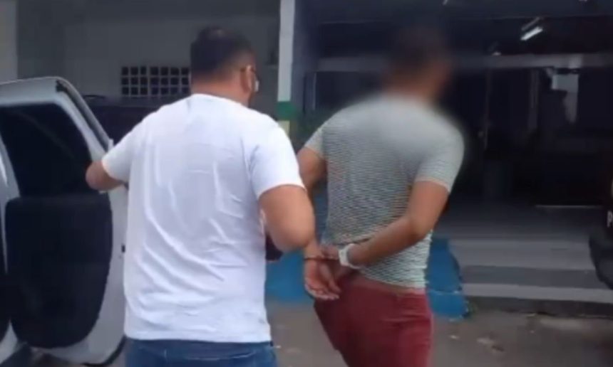 Homem é preso por estupro de vulnerável. Policial conduz suspeito algemado.