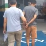 Homem preso sendo escoltado por policial