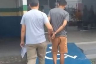 Homem preso sendo escoltado por policial