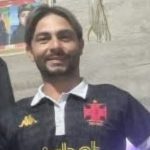 Homem sorrindo com camisa do Vasco, possivelmente Juninho, vítima de assassinato.