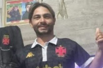 Homem sorrindo com camisa do Vasco, possivelmente Juninho, vítima de assassinato.