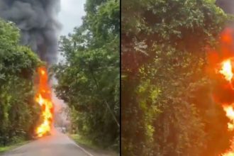 Incêndio em caminhão-tanque na BR-174 após tombamento, com chamas e fumaça densa.
