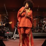 Jéssica Stephens cantando em festival de MPB, com banda ao fundo