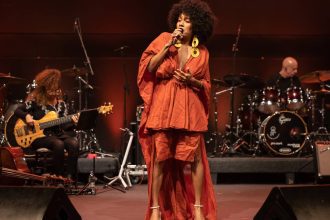 Jéssica Stephens cantando em festival de MPB, com banda ao fundo