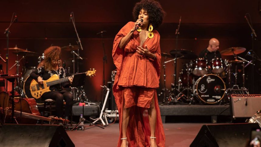 Jéssica Stephens cantando em festival de MPB, com banda ao fundo