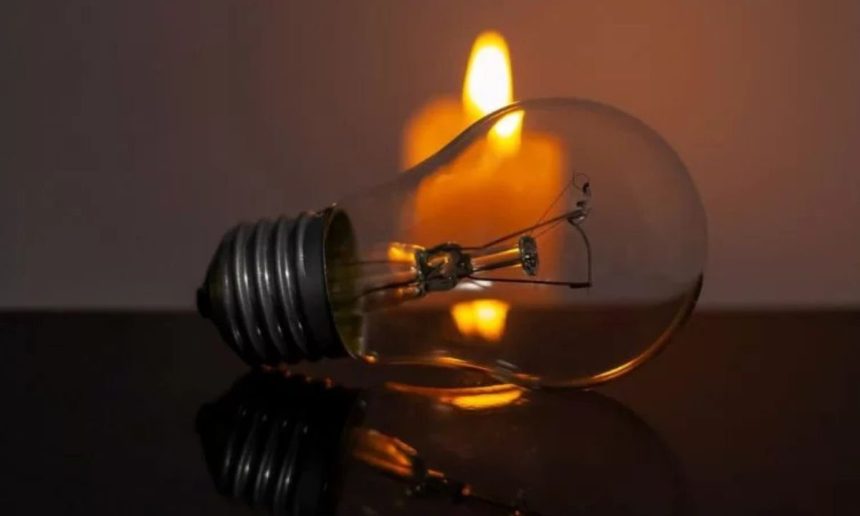 Lâmpada e vela acesa simbolizando falta de energia elétrica.