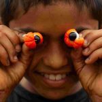 Menino com guaraná nos olhos, sorrindo para a câmera, representando a Rota do Guaraná.