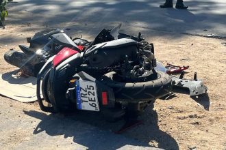 Motocicleta acidentada no chão, com danos visíveis.