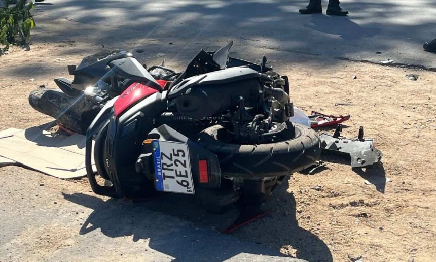Motocicleta acidentada no chão, com danos visíveis.