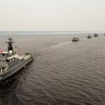 Navios da Marinha do Brasil navegando em formação no rio em Manaus.