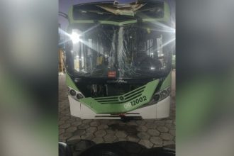 Ônibus danificado em Manaus após colisão com poste, com para-brisa quebrado e teto amassado.