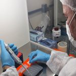 Pesquisador usando equipamentos de laboratório em ambiente hospitalar.