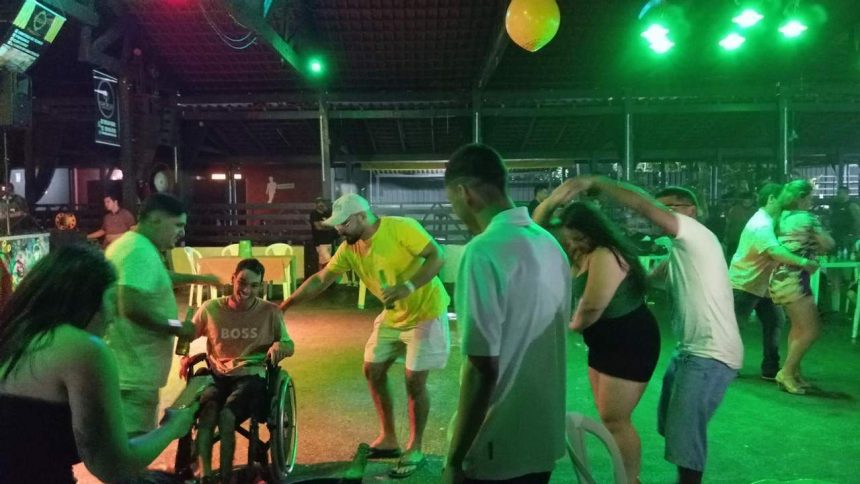 Pessoas dançando forró em casa de show em Manaus, com luzes verdes e balão amarelo.