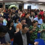 Pessoas em oração em igreja evangélica no Amazonas.