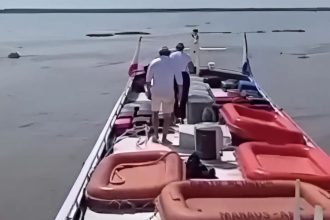Pessoas em um barco no Rio Amazonas, com botes salva-vidas a bordo.