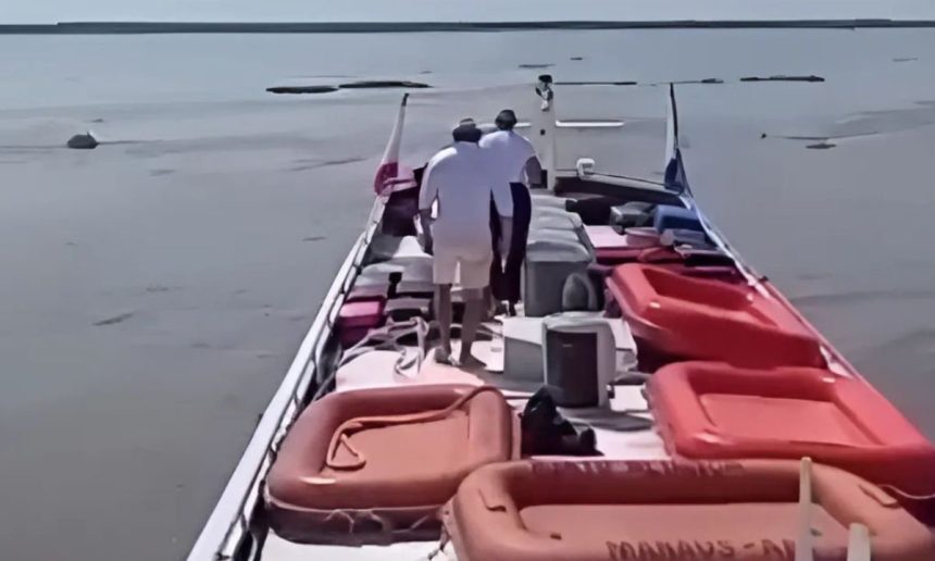 Pessoas em um barco no Rio Amazonas, com botes salva-vidas a bordo.