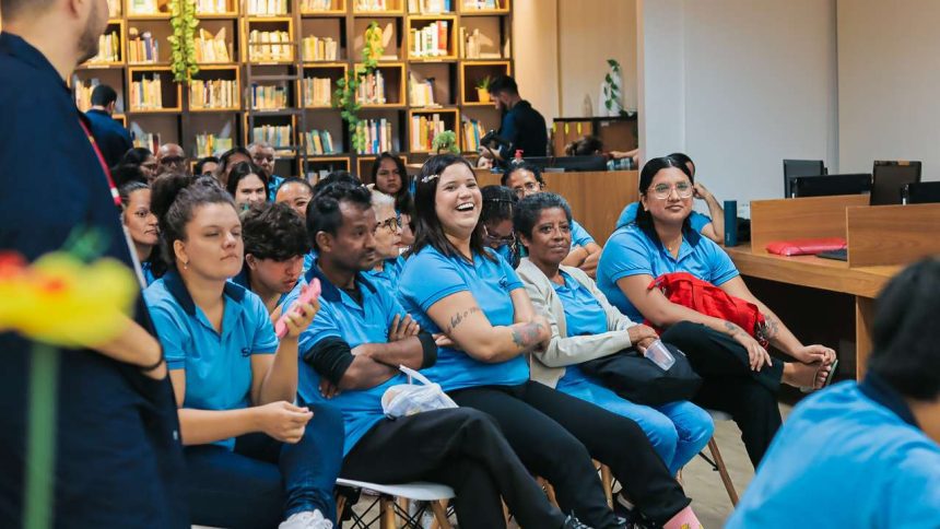 Pessoas reunidas em sala de aula, sorrindo e atentas.