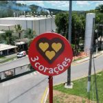 Placa da marca 3 Corações em frente a uma fábrica.