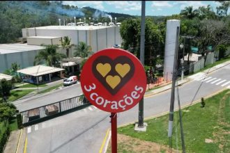 Placa da marca 3 Corações em frente a uma fábrica.