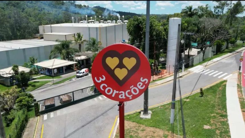 Placa da marca 3 Corações em frente a uma fábrica.