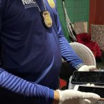 Policial segura celulares apreendidos durante operação policial.