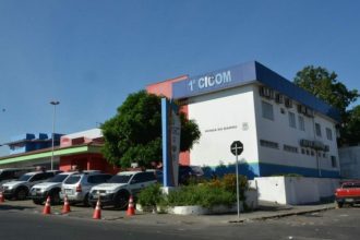 Prédio da polícia em Manaus com viaturas estacionadas.