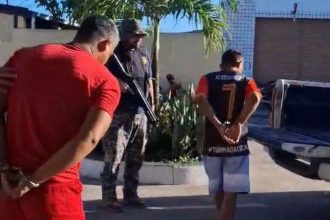 Prisão de homens após denúncia em delegacia. Policial com arma acompanha.