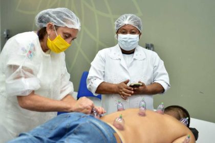 Profissionais aplicam ventosas em paciente durante curso de Qualificação Profissional.