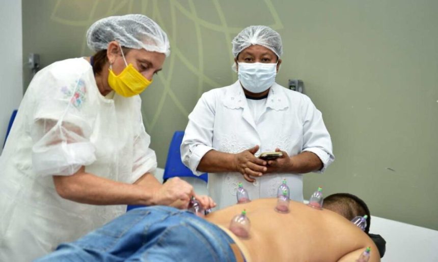 Profissionais aplicam ventosas em paciente durante curso de Qualificação Profissional.