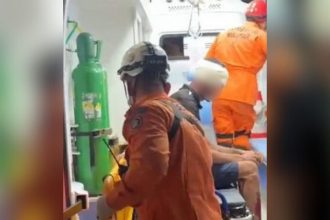 Socorristas atendendo vítima em ambulância. Cena de resgate após agressão.