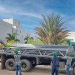 Trabalhadores descarregando materiais de construção de um caminhão em Manaus, construtora.