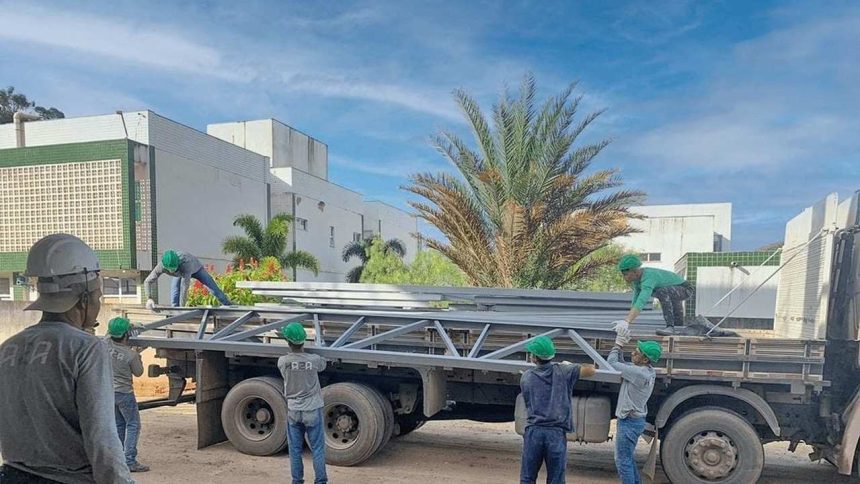 Trabalhadores descarregando materiais de construção de um caminhão em Manaus, construtora.