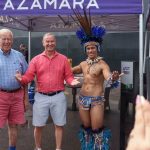 Turistas posam com dançarinos em trajes típicos da região amazônica.
