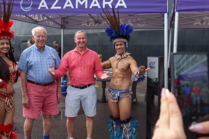 Turistas posam com dançarinos em trajes típicos da região amazônica.