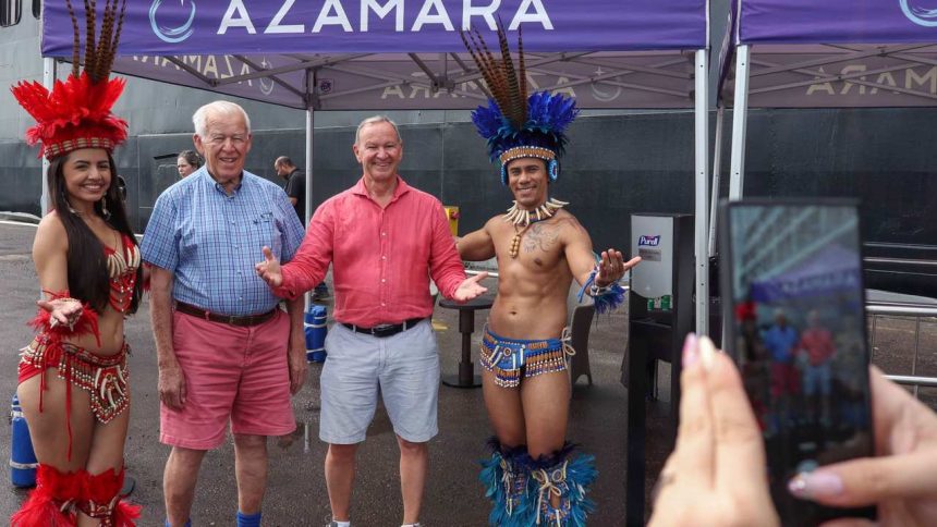 Turistas posam com dançarinos em trajes típicos da região amazônica.