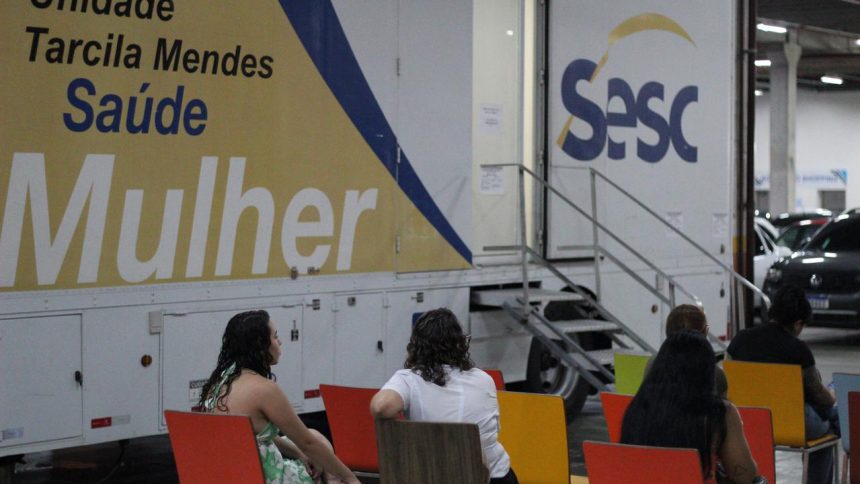 Unidade móvel Sesc Saúde Mulher, com pessoas esperando atendimento.