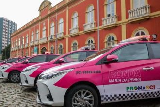 Viaturas da Ronda Maria da Penha estacionadas em frente a um prédio histórico.