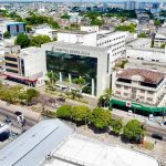Vista aérea do Hospital Santa Júlia em Manaus, com prédios, ruas e vegetação.