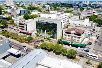 Vista aérea do Hospital Santa Júlia em Manaus, com prédios, ruas e vegetação.