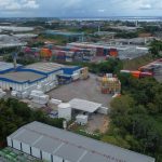 Vista aérea do Polo Industrial de Manaus com contêineres e galpões.
