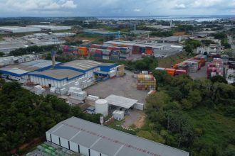 Vista aérea do Polo Industrial de Manaus com contêineres e galpões.