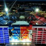 Vista noturna do Bumbódromo em Parintins, Amazonas, com iluminação colorida e detalhes da arquitetura.