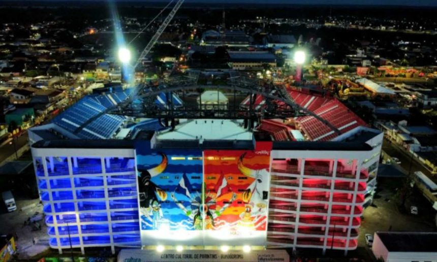 Vista noturna do Bumbódromo em Parintins, Amazonas, com iluminação colorida e detalhes da arquitetura.