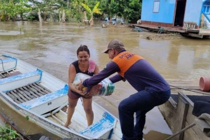 Voluntário entrega cestas básicas para vítima de enchente no Amazonas.
