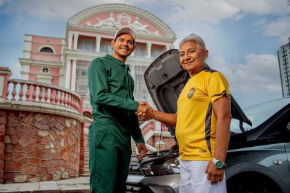 Imagem colorida mostra gesto de parceria em frente ao Teatro Amazonas da Sicredi